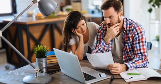 Frustrated couple checking bills