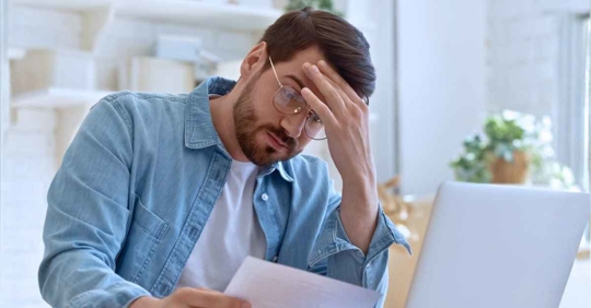 Upset frustrated young man holding reading mail letter